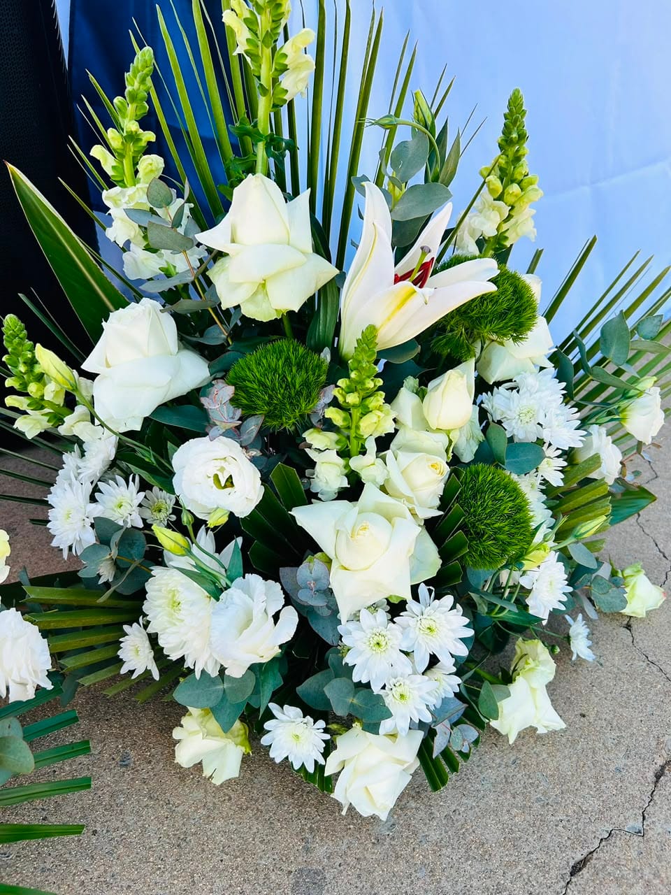 White and cream funeral flower arrangement at the graveside