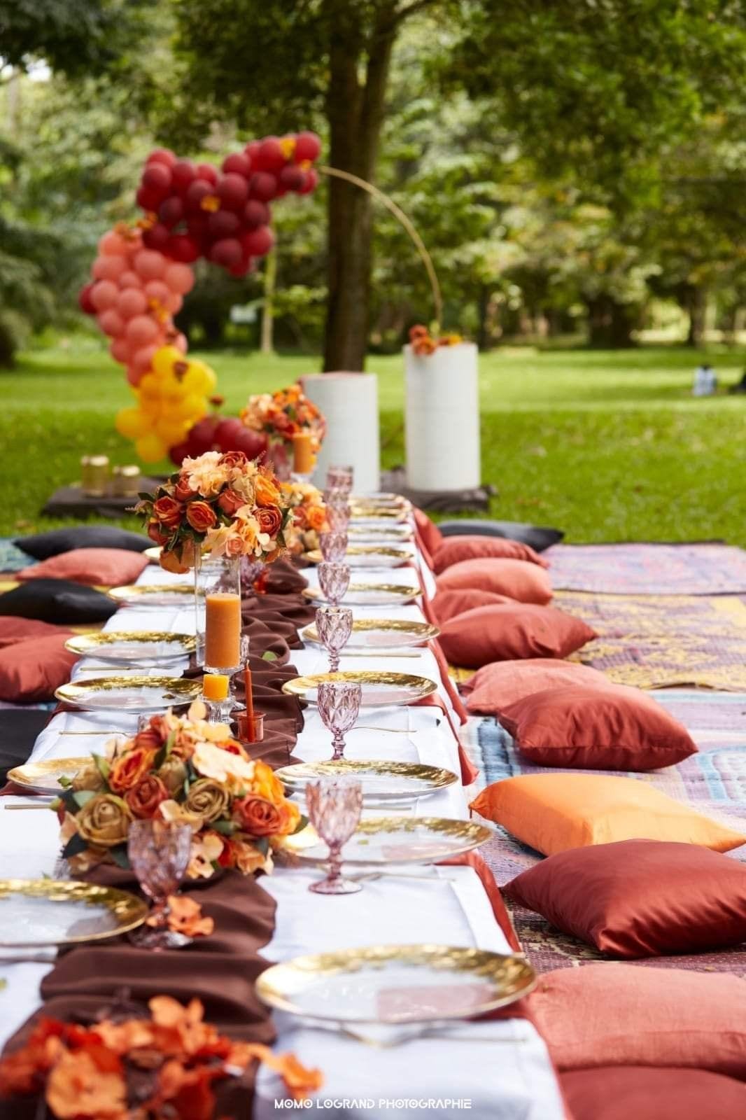 Outdoor grazing table with warm autumn florals and cushions