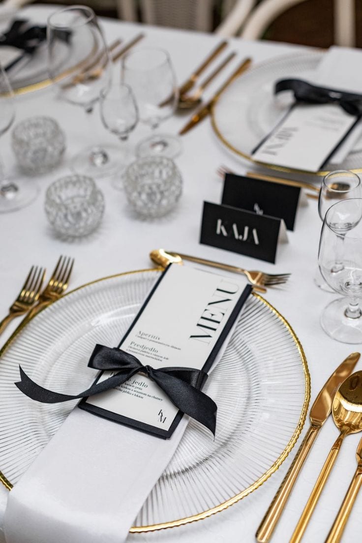 Fine-dining place setting with gold cutlery and a name card